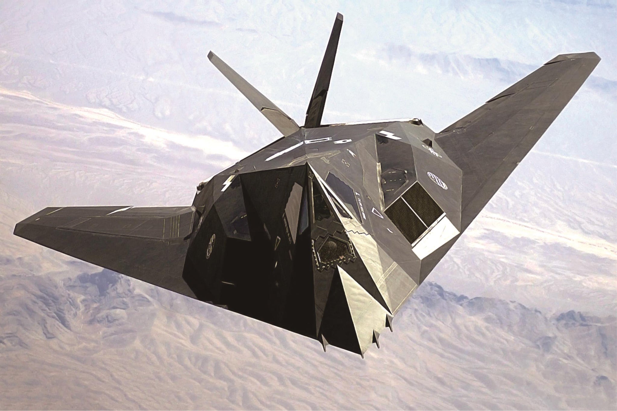 Stealth aircraft flying in the sky with a mountainous landscape below